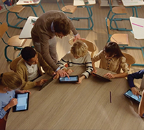 A teacher engages with students in a multimedia classroom