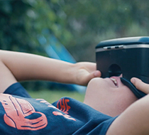 a child wearing a vr headset in a grassy field