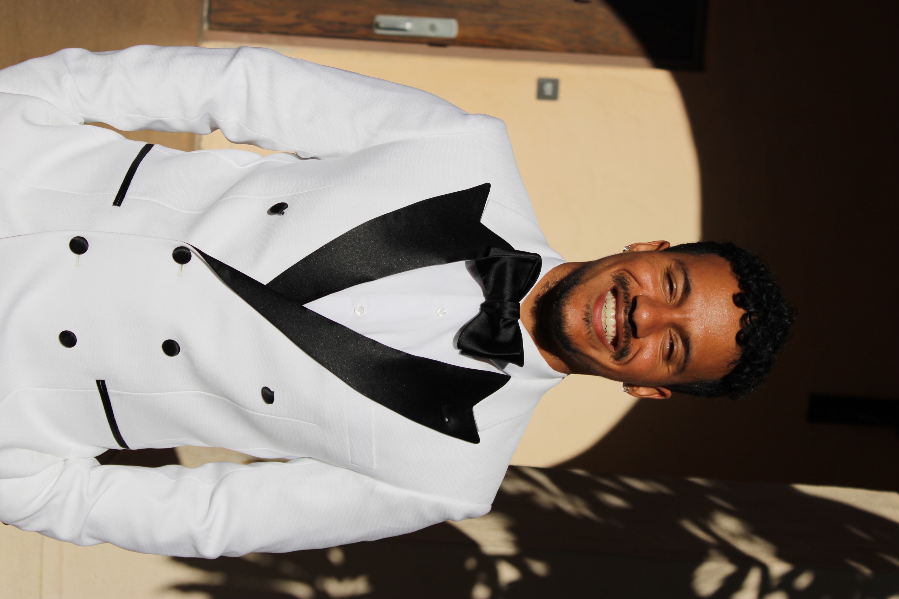 An image of Tray Herod smiling for the camera in a white suit.