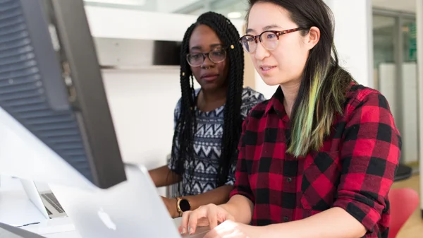 Two students work together at a computer.