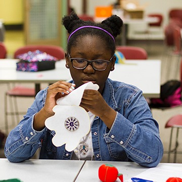 A black girl engaged in a stem activity with paper
